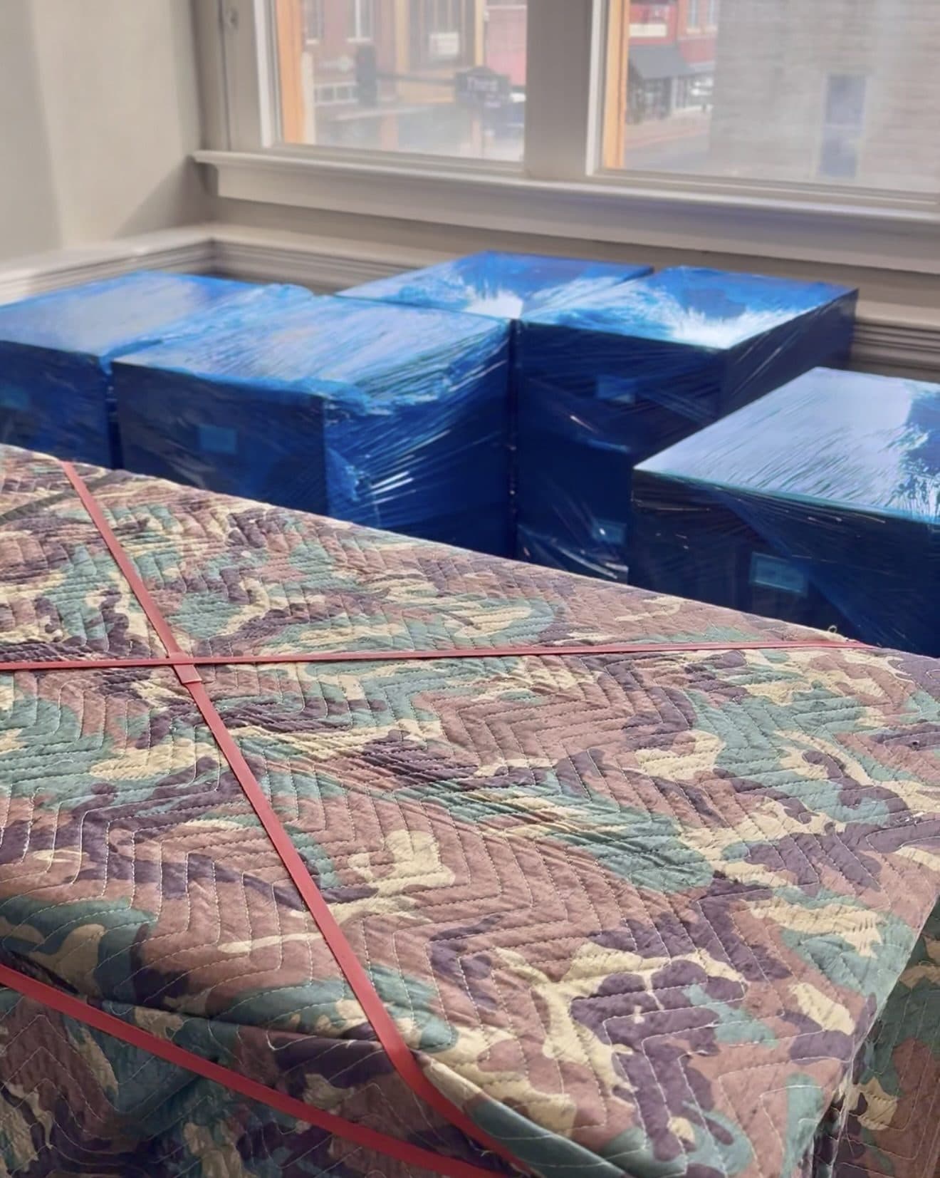Office furniture shrink-wrapped and padded during a commercial move