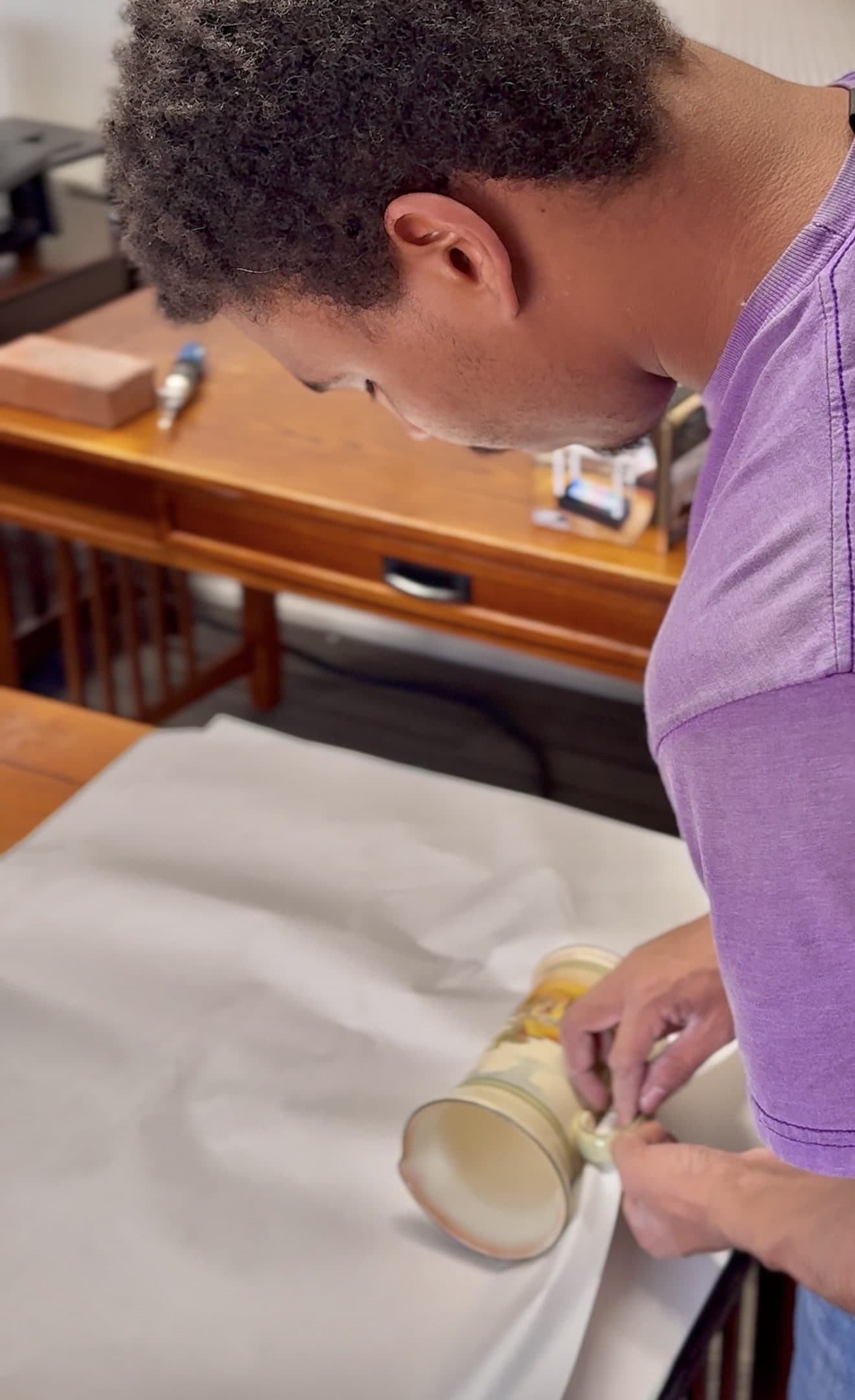 A Jam'N Moving crew member wrapping a ceramic vase in packing paper